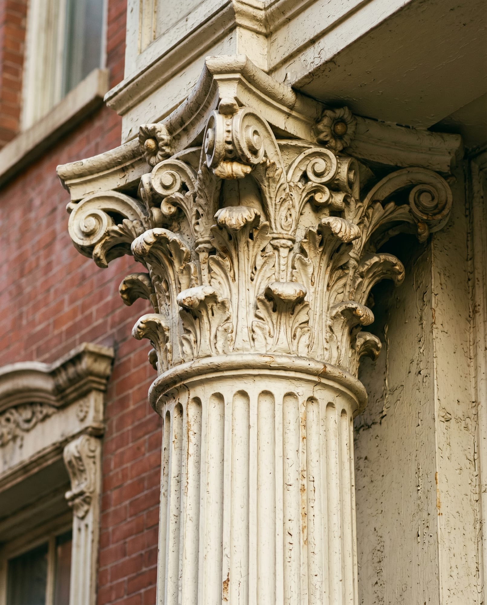 Detail of an original cast-iron column — fluted shaft, century-old paint layers.